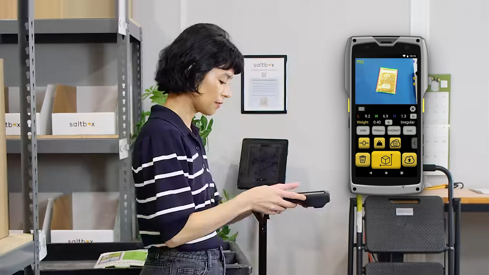 An operator measures a polybag with the M2; the Item & Parcel app shows the bag outlined at 9.2 × 6.9 × 1.3 in and 0.40 lb