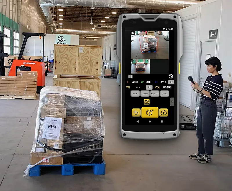 The M2 showing the Pallets app result for a stretch-wrapped pallet: outlined in the photo, 48.0 × 40.0 × 42.4 in; the pallet and the operator holding the M2 on either side